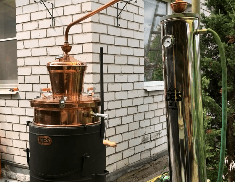 Дистилляция в аламбике Дистилляция кальвадоса в медном перегонном кубе при лунном свете в соответствии с нормандскими традициями.